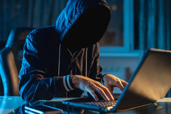 Programmer hacker anonim menggunakan laptop untuk meretas sistem dalam gelap. Konsep kejahatan cyber dan hacking database — Stok Foto