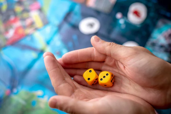 Hände werfen gelbe Würfel auf das Spielfeld. Glück und Aufregung. Konzept der Brettspiele. Spielmomente in Dynamik — Stockfoto