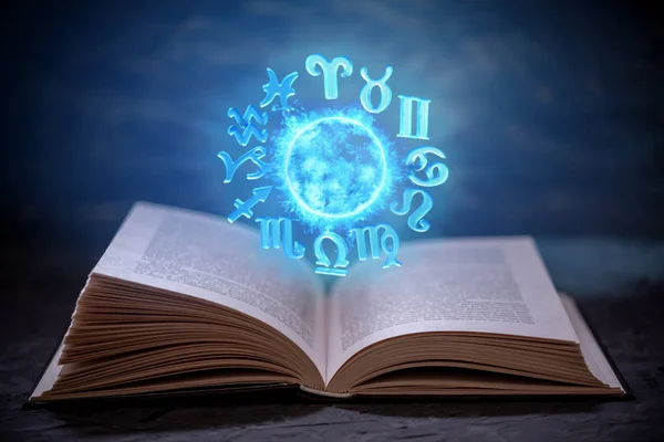 Livro aberto sobre astrologia sobre um fundo escuro. Globo mágico brilhante com sinais do zodíaco na luz azul . — Fotografia de Stock