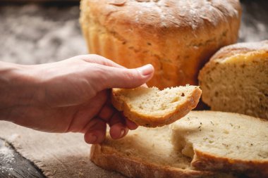 Eller eski ahşap arka plan üzerinde altın bir kabuk ile ev yapımı doğal taze ekmek kırma. Fırın ürünleri