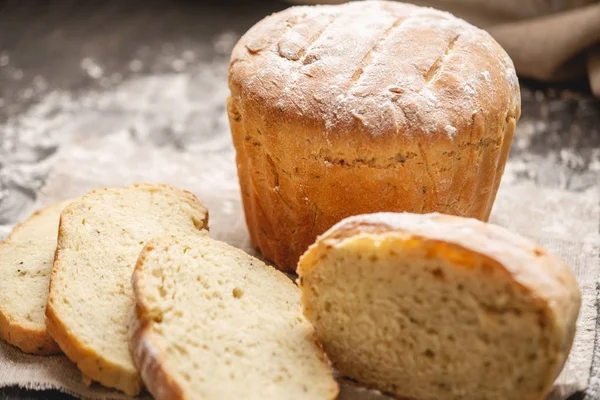 Hausgemachtes frisches Naturbrot mit goldener Kruste auf Serviette auf altem Holzgrund. Backwaren backen — Stockfoto