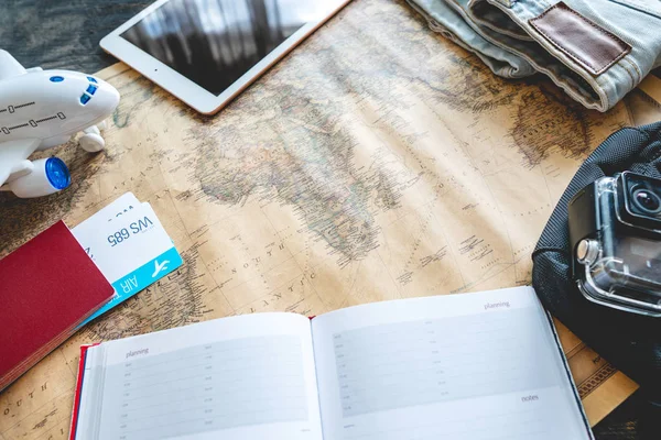 Air tickets, passport, camera, tablet, jeans and map on the table. Gathering for a trip or travel to meet adventures. — Stock Photo, Image