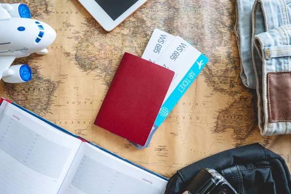 Billetes de avión, pasaporte, cámara, tablet, jeans y mapa sobre la mesa. Reuniones para un viaje o viajes para conocer aventuras . —  Fotos de Stock