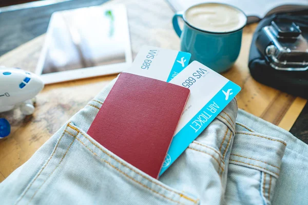 Διαβατήριο και δύο αεροπορικά εισιτήρια που βγαίνουν από την τσέπη του Τζην. Συγκέντρωση για ένα ταξίδι ή ταξίδι για να συναντήσετε περιπέτειες. — Φωτογραφία Αρχείου