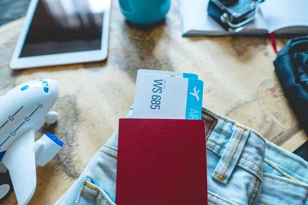 Pasaporte y dos billetes de avión que salen del bolsillo de los vaqueros. Reuniones para un viaje o viajes para conocer aventuras . — Foto de Stock