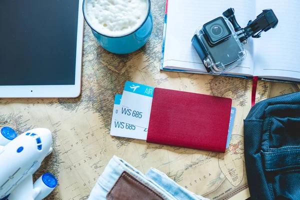 Billetes de avión, pasaporte, cámara, tablet, jeans y mapa sobre la mesa. Reuniones para un viaje o viajes para conocer aventuras . —  Fotos de Stock
