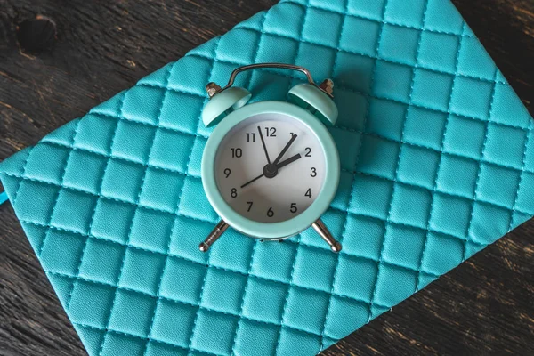 Reloj despertador de metal analógico azul sobre fondo azul con estilo. Concepto de tiempo en colores pastel y oscuro — Foto de Stock