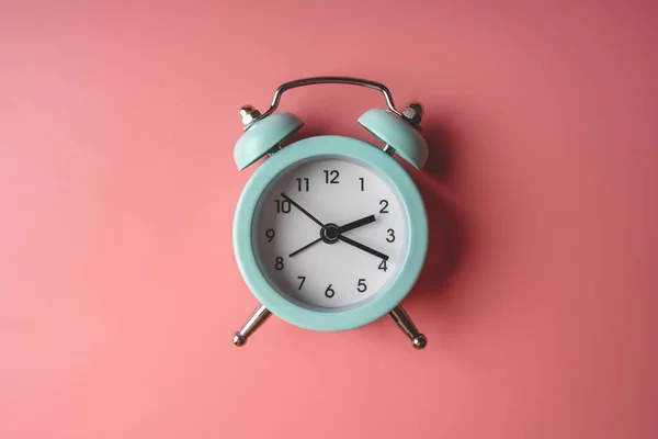 Reloj despertador metálico analógico azul sobre fondo rosa con estilo. Concepto de tiempo en colores pastel — Foto de Stock