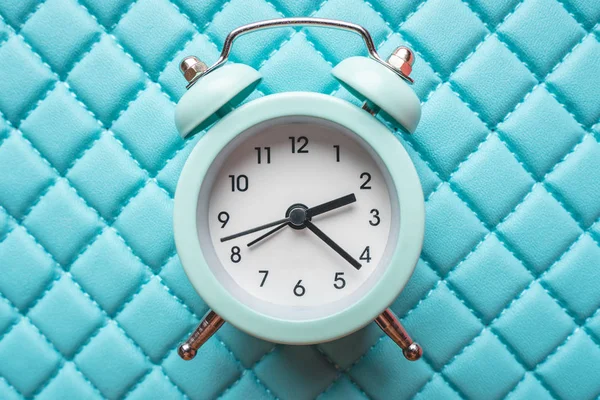 Reloj despertador de metal analógico azul sobre fondo azul con estilo. Concepto de tiempo en colores pastel — Foto de Stock