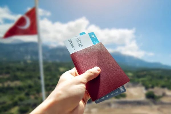 Mano con pasaporte y dos pasajes aéreos en el fondo del paisaje turco. Viajes y vacaciones en lugares hermosos — Foto de Stock