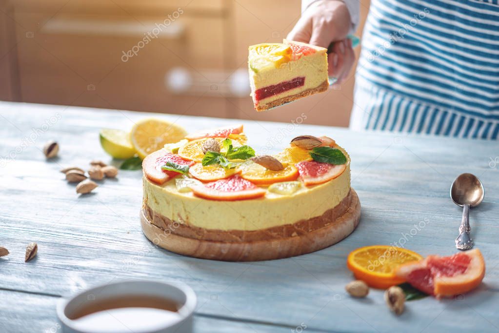 A piece of raw citrus cake with grapefruit, orange, lime and lemon. Healthy fresh summer dessert. Homemade vegan food