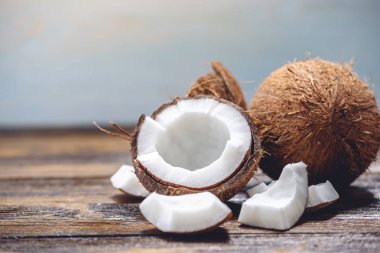 Ahşap arka plan üzerinde beyaz hamuru ile açık hindistan cevizi. Kozmetikte yaygın olarak kullanılan organik sağlıklı vegan ürün