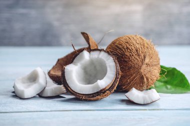 Mavi ahşap arka plan üzerinde beyaz hamuru ile açık hindistan cevizi. Kozmetikte yaygın olarak kullanılan organik sağlıklı vegan ürün