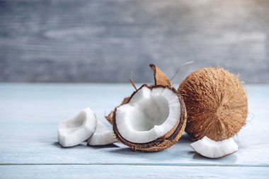 Mavi ahşap arka plan üzerinde beyaz hamuru ile açık hindistan cevizi. Kozmetikte yaygın olarak kullanılan organik sağlıklı vegan ürün