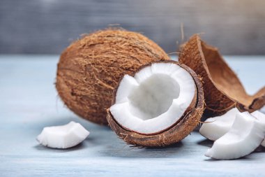 Mavi ahşap arka plan üzerinde beyaz hamuru ile açık hindistan cevizi. Kozmetikte yaygın olarak kullanılan organik diyet vegan ürün