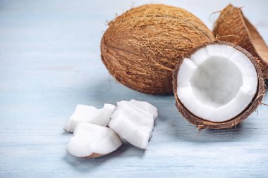 Mavi ahşap arka plan üzerinde beyaz hamuru ile açık hindistan cevizi. Kozmetikte yaygın olarak kullanılan organik diyet vegan ürün