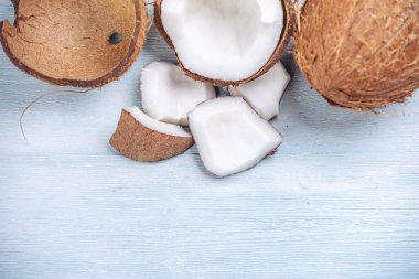 Mavi ahşap arka plan üzerinde beyaz hamuru ile açık hindistan cevizi. Kozmetikte yaygın olarak kullanılan organik diyet vegan ürün