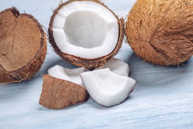 Mavi ahşap arka plan üzerinde beyaz hamuru ile açık hindistan cevizi. Kozmetikte yaygın olarak kullanılan organik sağlıklı diyet ürünü