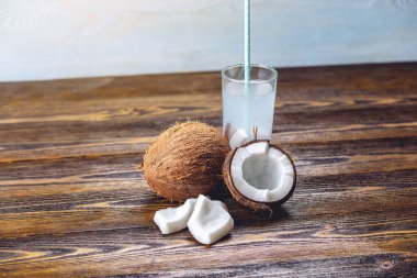 Ahşap arka plan üzerinde beyaz eti ile kompozisyon Hindistan cevizi suyu. Kozmetolojide yaygın olarak kullanılan organik ürün