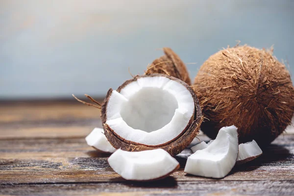 Ahşap arka plan üzerinde beyaz hamuru ile açık hindistan cevizi. Kozmetikte yaygın olarak kullanılan organik sağlıklı vegan ürün