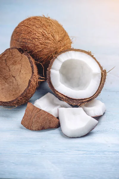 Mavi ahşap arka plan üzerinde beyaz hamuru ile açık hindistan cevizi. Kozmetikte yaygın olarak kullanılan organik sağlıklı diyet ürünü