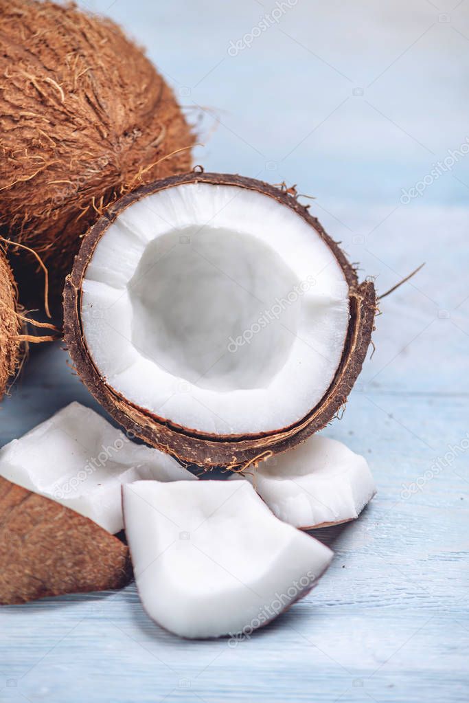 Open coconut with white pulp on blue wooden background. Organic healthy dietary product widely used in cosmetics