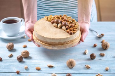 Ceviz, badem, mavi ahşap arka plan üzerinde fındık ile süslenmiş çiğ fındık kek. Glutensiz ve şekersiz gıda