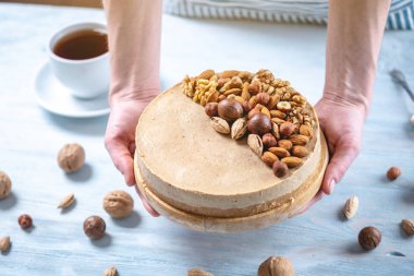 Ceviz, badem, mavi ahşap arka plan üzerinde fındık ile süslenmiş çiğ fındık kek. Glutensiz ve şekersiz gıda