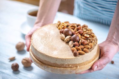 Ceviz, badem, mavi bir arka plan üzerinde fındık ile süslenmiş çiğ fındık kek. Glütensiz yiyecekler. Vegan tatlısı.