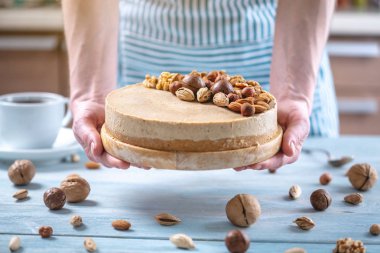 Ceviz, badem, mavi bir arka plan üzerinde fındık ile süslenmiş çiğ fındık kek. Glütensiz yiyecekler. Vegan tatlısı.