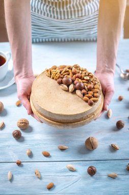 Ceviz, badem, fındık tepesi ile Nutty cheesecake. Mavi önlük süslenmiş ev yapımı tatlı şekerleme.