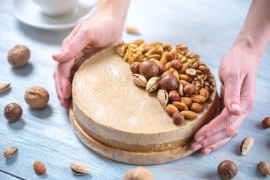 Ceviz, badem, fındık tepesi ile Nutty cheesecake. Mavi önlük süslenmiş ev yapımı tatlı şekerleme.