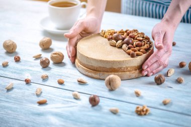 Ceviz, badem, mavi bir arka plan üzerinde fındık ile süslenmiş çiğ fındık kek. Glütensiz yiyecekler. Vegan tatlısı.