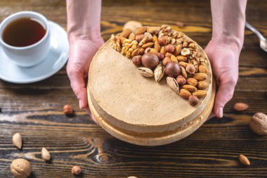 Koyu ahşap arka plan üzerinde ceviz, badem, fındık ile süslenmiş çiğ fındık kek. Glutensiz ve şekersiz gıda