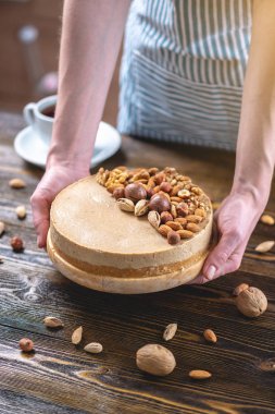 Koyu ahşap arka plan üzerinde ceviz, badem, fındık ile süslenmiş çiğ fındık kek. Sağlıklı taze vegan tatlı.