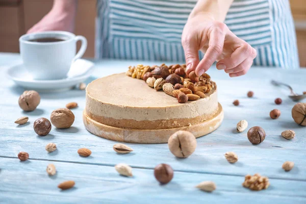 Ceviz, badem, mavi ahşap arka plan üzerinde fındık ile süslenmiş çiğ fındık kek. Glutensiz ve şekersiz gıda