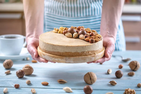 Ceviz, badem, mavi bir arka plan üzerinde fındık ile süslenmiş çiğ fındık kek. Glütensiz yiyecekler. Vegan tatlısı.