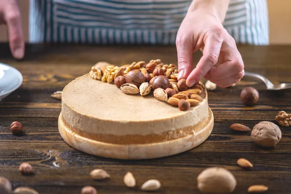 Koyu ahşap arka plan üzerinde ceviz, badem, fındık ile süslenmiş çiğ fındık kek. Glutensiz ve şekersiz gıda