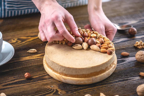 Koyu ahşap arka plan üzerinde ceviz, badem, fındık ile süslenmiş çiğ fındık kek. Glutensiz ve şekersiz gıda