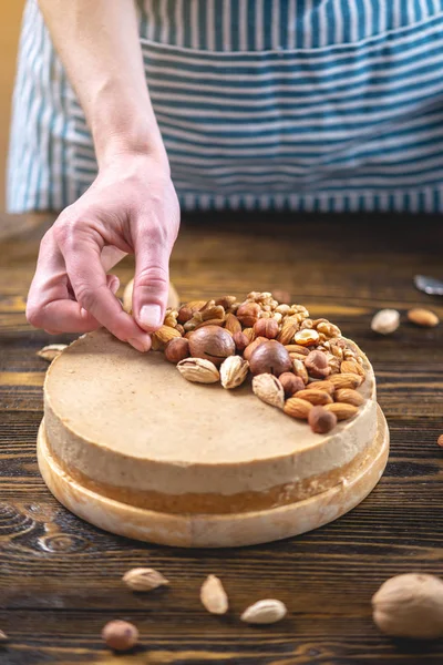 Ceviz, badem, fındık tepesi ile Nutty cheesecake. Mavi önlük süslenmiş ev yapımı tatlı şekerleme.