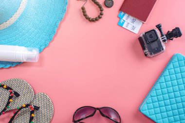 Seyahat tatil malzemeleri: şapka, güneş gözlüğü, pembe arka plan pasaport. Denizde tatile gitme kavramı. Üstte görüntü