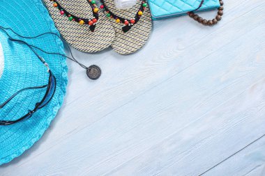 Seyahat tatil malzemeleri: şapka, güneş gözlüğü, parmak arası terlik, mavi arka plan kamera pasaport. Denize bir geziye çıkmak