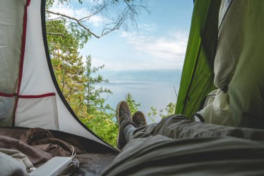 Baykal Gölü'ndeki çadırdan tepedeki çam ağaçlarının arasından manzara. Gezegenin güzel yerlerinde Rekreasyon.