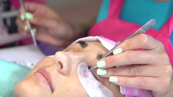 Woman master in the beauty salon work on eyelash extension to the client. Profession in the field of beauty services — Stock Video