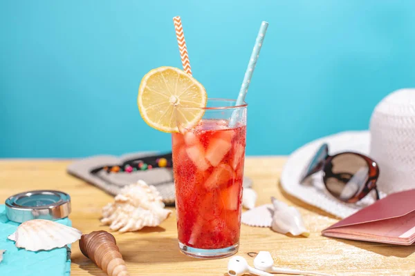 Et glas rød limonade drik med citron og halm på bordet. Tilbehør til sommer Solrig ferie i feriestedet - Stock-foto