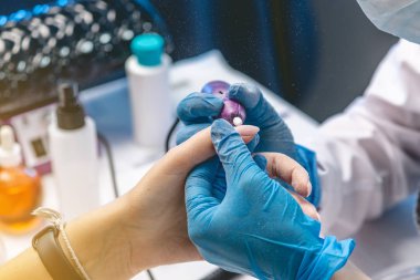 Kadın manikürcü salonda eski vernik kaldırarak manikür donanım kesici yapıyor. Profesyonel tırnak bakımı kavramı