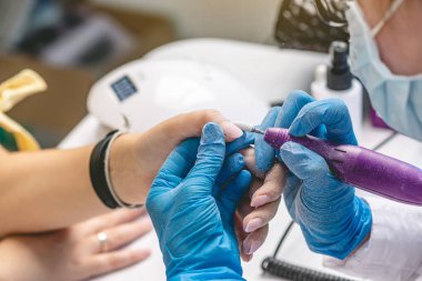 Manikür yapan kadın manikürcü kuaförde eski verniği temizliyor. Güzellik uzmanı tırnak bakımı