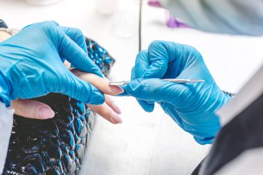 Kadın manikürcü, kabinde satıcıyla manikür yapıyor. Güzellik anlayışı profesyonel tırnak bakımı