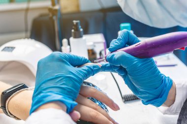 Kadın manikür ustası salonda manikür kaldırarak bir donanım manikür kesici yapar. Güzellik profesyonel tırnak bakımı