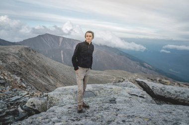 İnsan yürüyüşçüsü dağın zirvesinde duran manzaraya hayran kalmaktadır. Hedef başarı ve aktif yaşam